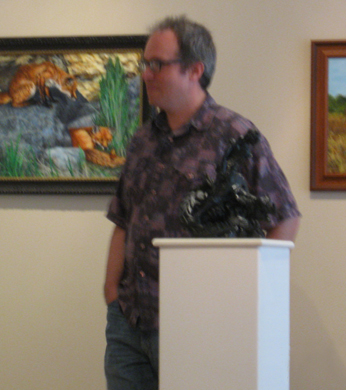 Artist with paintings and sculpture